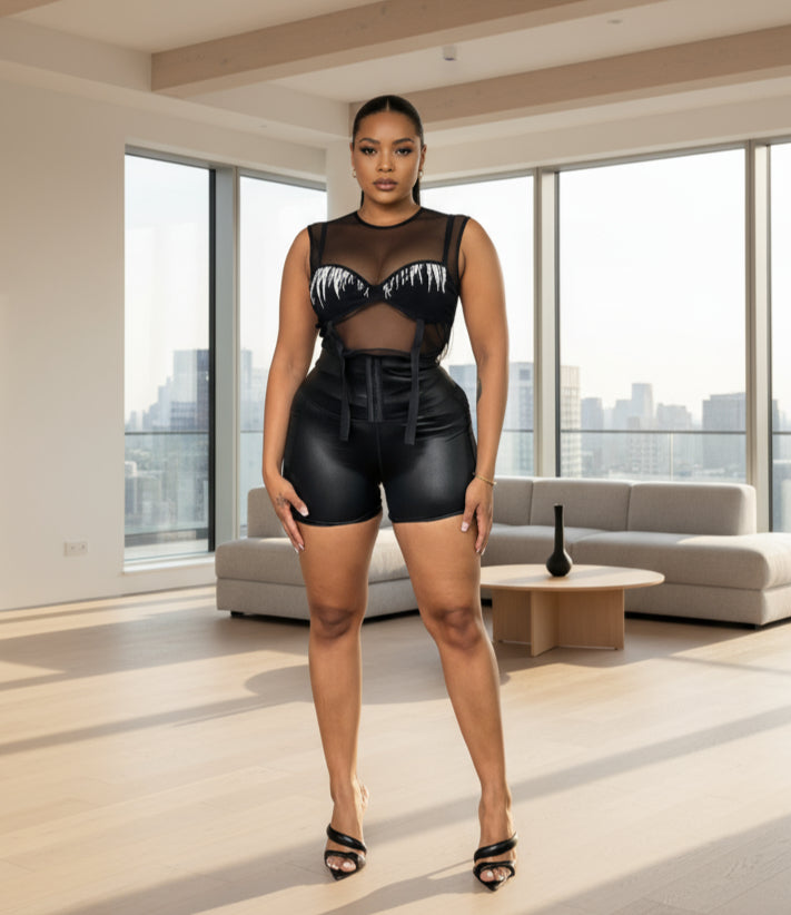 A person wearing black corset waist shorts that reach mid-thigh, paired with a black crop top.